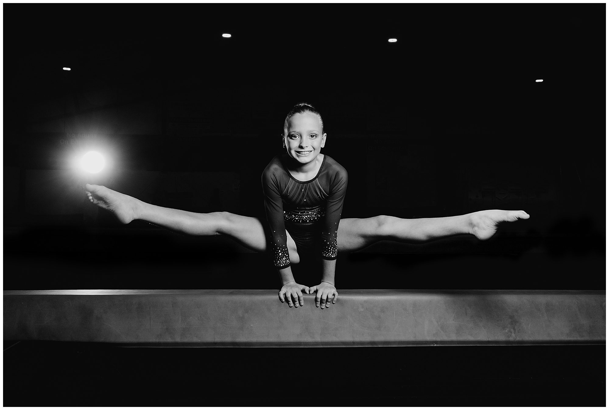 a young female does the splits on the bar for photos